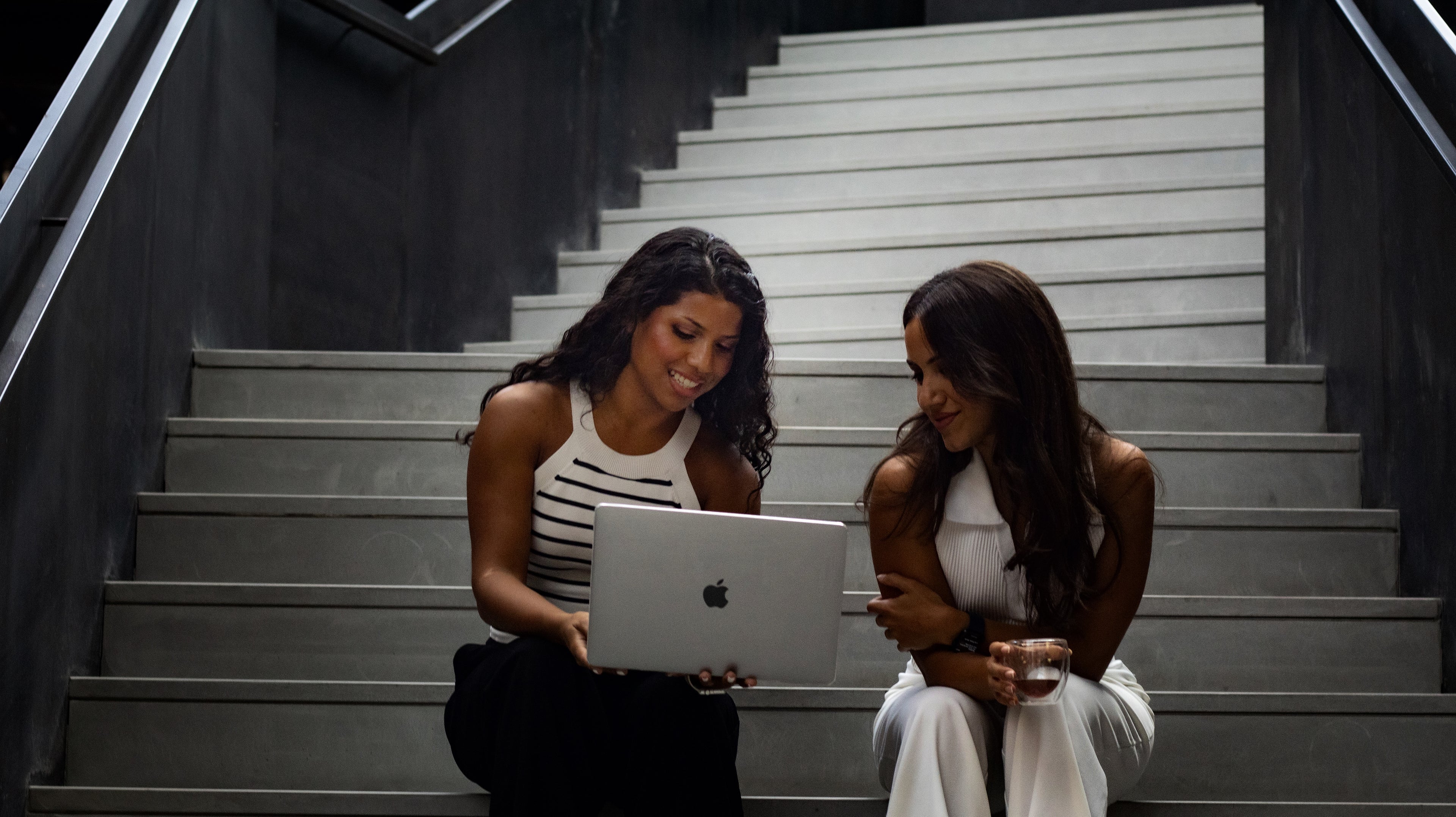 Valentina & Lurdes sitting on a staircase looking at a laptop, working a new project for Casa Eva, Dubai, UAE based.